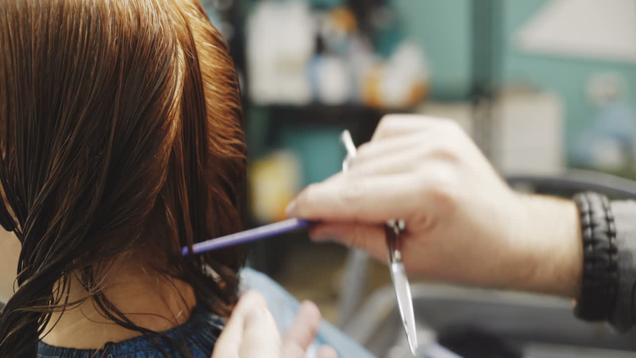 Stylish male hairdresser cuts the hair of a beautiful woman in a beauty salon. Beauty industry concept