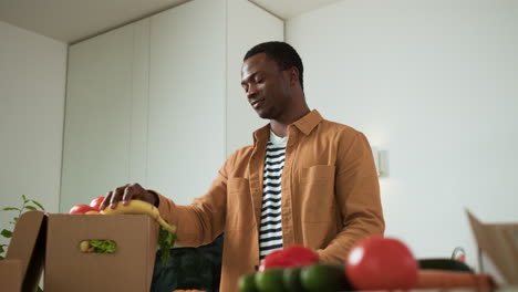 hombre desempaquetando verduras