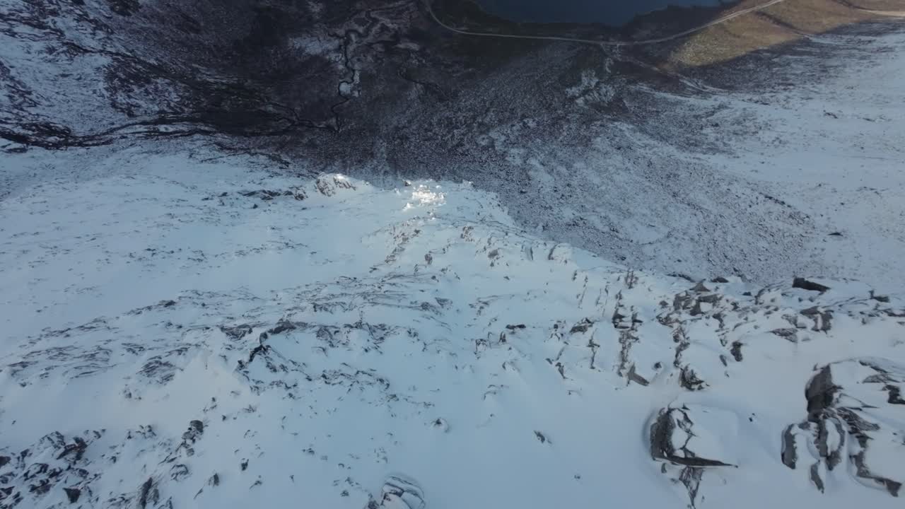 노르웨이 북부의 수직 면에서 다이빙을 하면서 아래의 차가운 피오르드를 드러니다.