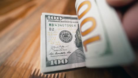 volteando billetes de 100 dólares de cerca a la cámara
