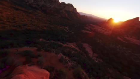 Aerial-shot-of-two-people-standing-on-the-edge-off-a-cliff-in-Sedona,-Arizona