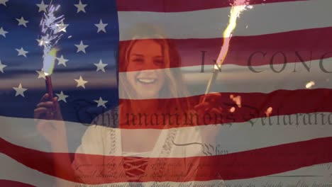 Caucasian-woman-laughing-and-using-fireworks-with-US-flag-waving-and-independence-declaration-foregr