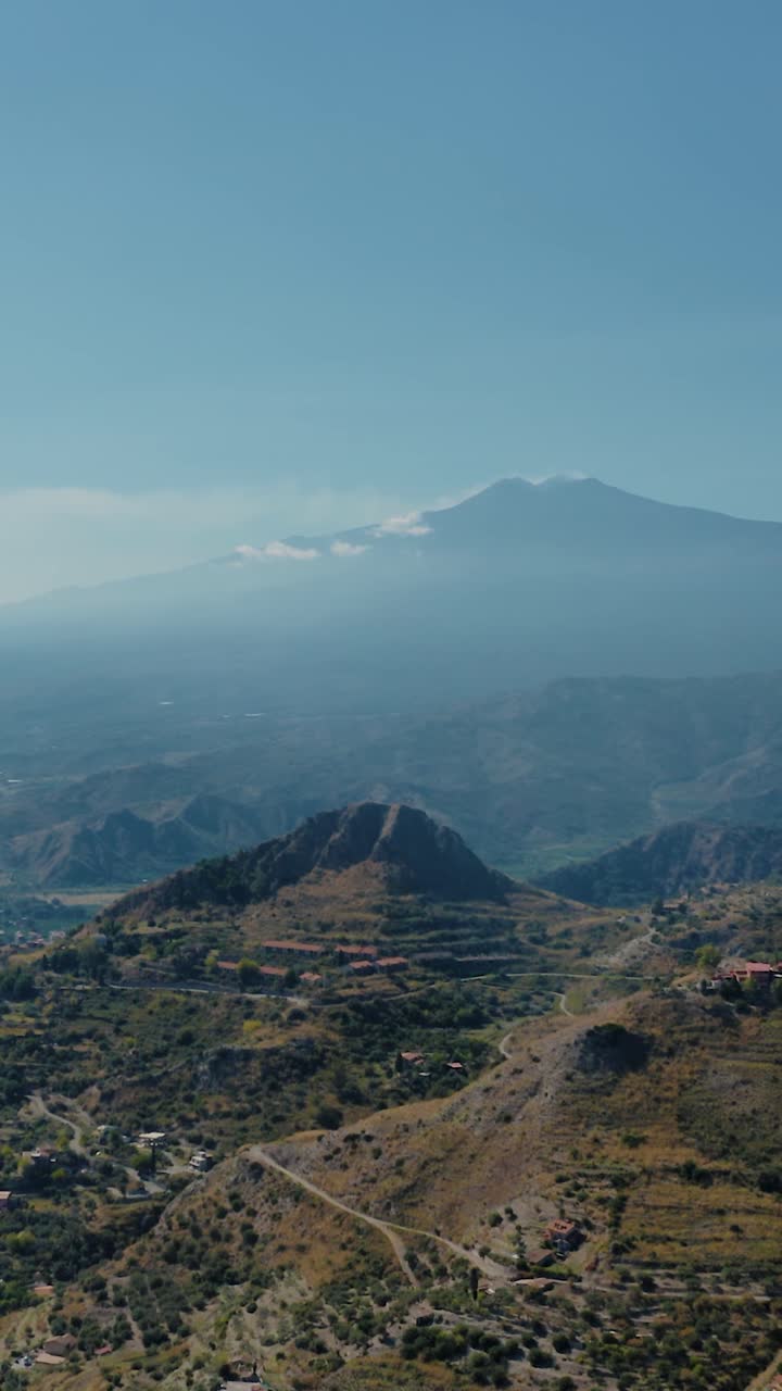 Ripresa verticale con drone che sorvola un'area montuosa con una chiara vista della cima dell'Etna. Panorami mozzafiato della Sicilia, Italia.