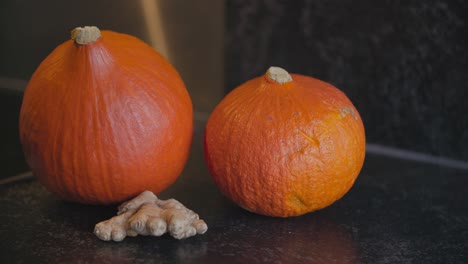 two orange pumpkins and ginger ready to be used for soup ingredients or halloween decoration