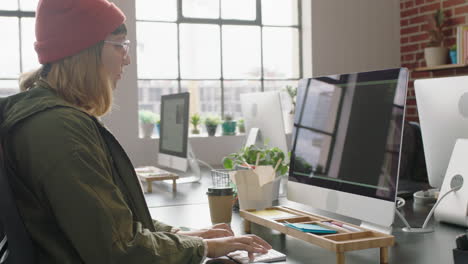 Joven-Mujer-Caucásica-Programadora-Codificando-Software-De-Seguridad-De-Red-Para-Una-Empresa-Emergente-Desarrollador-Web-Profesional-Escribiendo-Código-En-La-Pantalla-De-La-Computadora-En-Una-Moderna-Oficina-De-Inicio