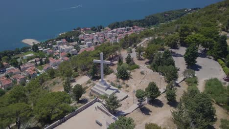 flying away from the white stone cross of park suma marjan, split, croatia, with the adriatic sea in the background