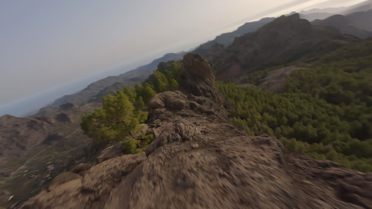 vista aérea rápida fpv siguiendo roque nublo bosque extremo cresta de la montaña rocosa gran canaria