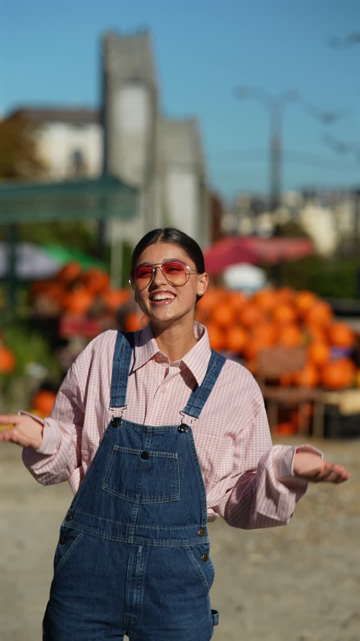 una adolescente en mono en un campo de calabazas