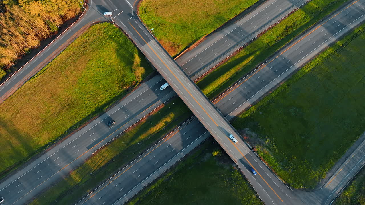 Cars and trucks move by the highways and freeways in the suburbs. Top view on the roads in the countryside.