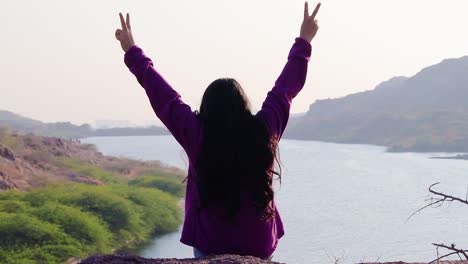 isolated young girl at mountain top with lake view backbit shot from flat angle video is taken at kaylana lake jodhpur rajasthan india