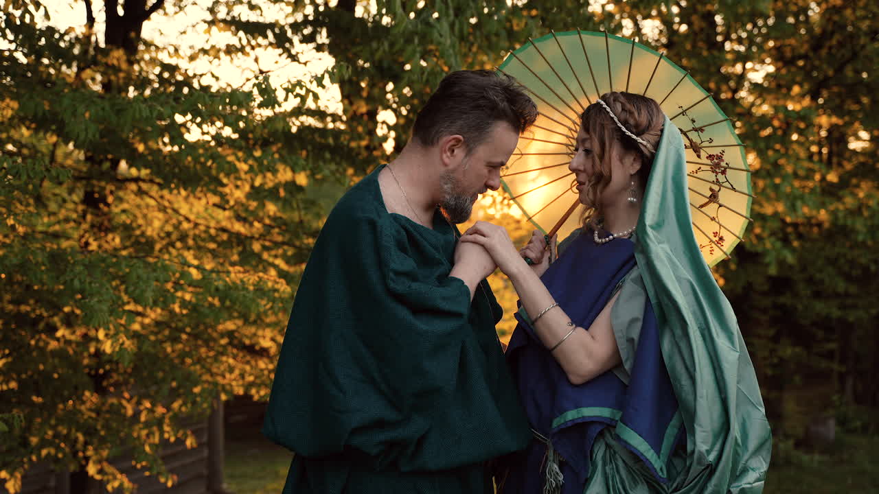 Couple in Historical Attire Under an Umbrella
