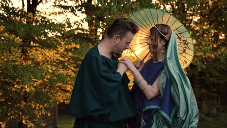 couple in historical attire under an umbrella
