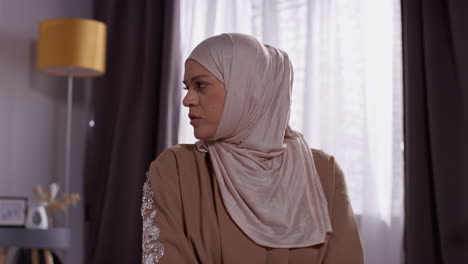 primer plano de una mujer musulmana con hijab en casa orando arrodillada en la alfombra de oración 7