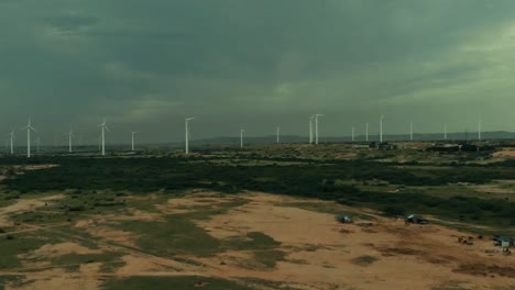 aerial flying towards jhimpir wind power plant with storm clouds overhead