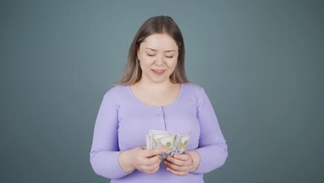 mujer joven contando dinero mirando a la cámara.