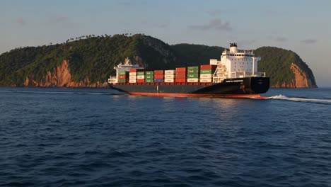 container ship sailing past islands