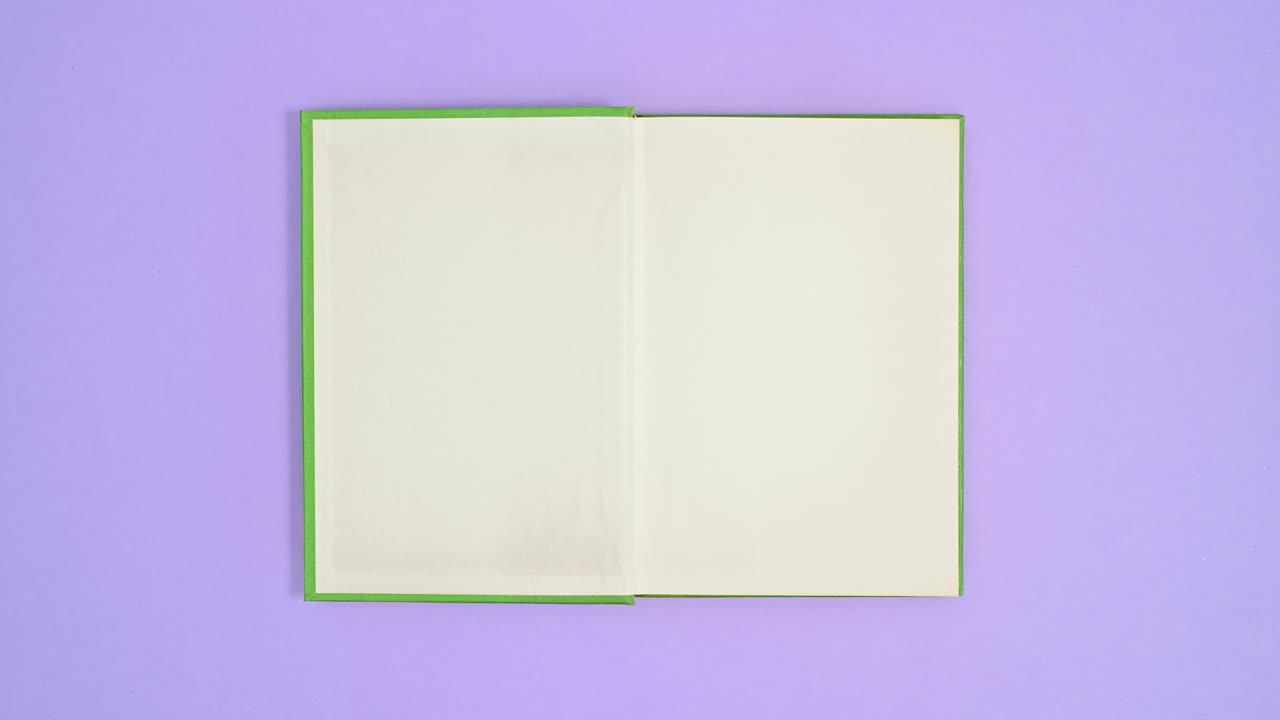 Light green hardcover retro book come on purple theme and open. Stop motion flat lay
