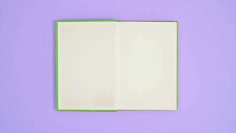 light green hardcover retro book come on purple theme and open. stop motion flat lay