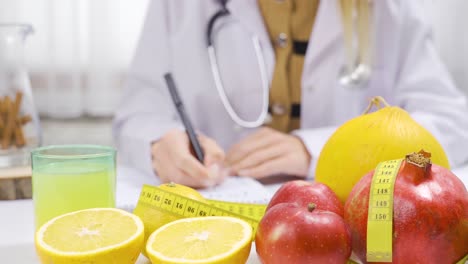 A-dietitian-working-at-a-fruit-filled-table-prepares-a-healthy-menu.