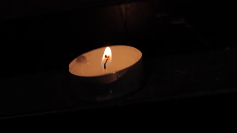 A-lit-candle-in-a-church-in-Poland,-captured-in-4K-resolution