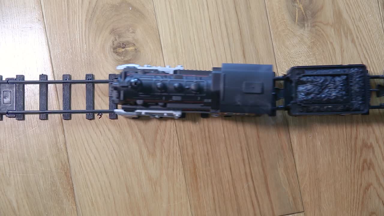 증기를 방출하는 철도를 타는 플라스틱 장난감 기차에 대한 하향식 보기