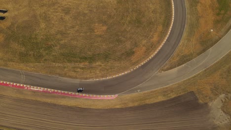 top down overhead circling view of one vintage car driving on race track of buenos aires autodromo circuit