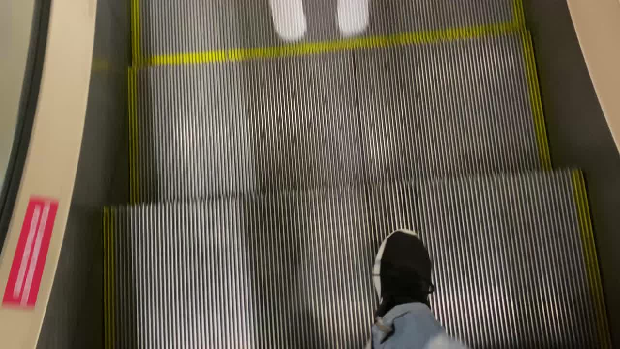 Person's Feet on an Escalator