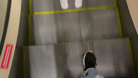 person's feet on an escalator