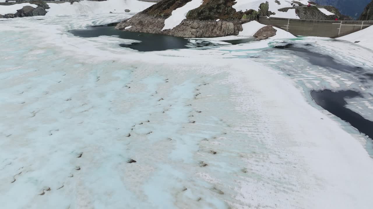 Totensee frozen lake and dam of Grimsel Pass in Switzerland