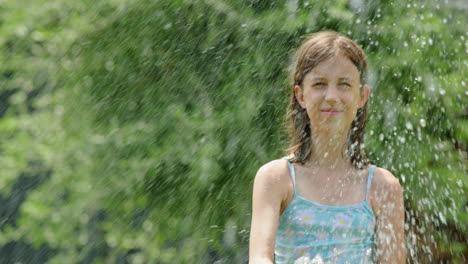 girl playing with water hose in garden