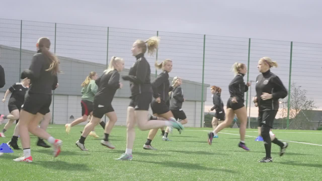 Amateur women soccer players, evening fitness session, astroturf facility