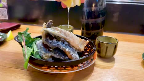 fried fish served with lemon and greens