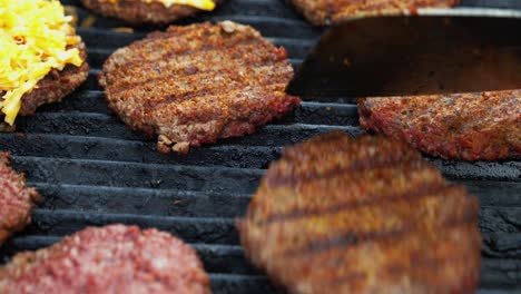 hamburguesas imposibles basadas en plantas de barbacoa en una parrilla eléctrica semiprimer plano panorámica sobre una espátula volteada y hamburguesas condimentadas marrones a la parrilla - en el cine 4k