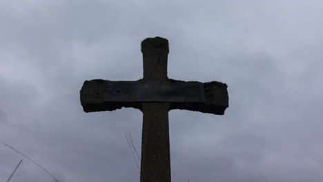 time lapse of grey and dark clouds passing over old gravestone - zoom out