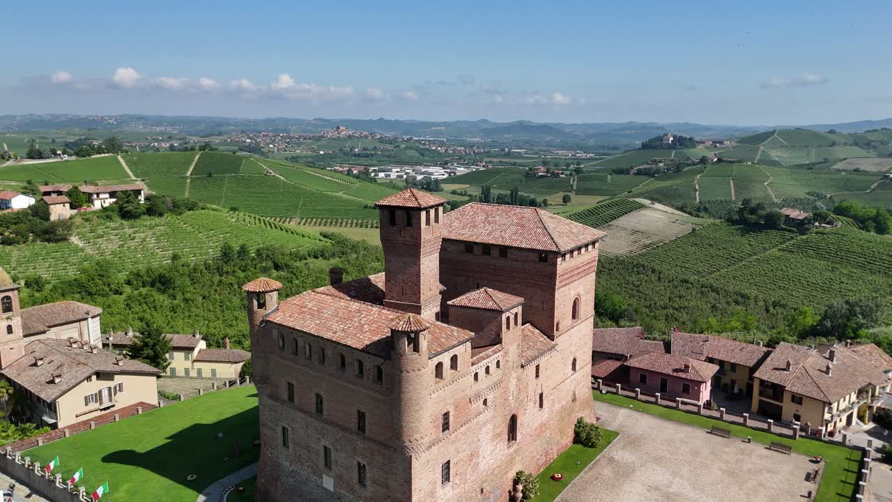 Grinzane Cavour castle, UNESCO site, Cuneo, Piedmont, Italy. 4k aerial view of the castle together with the Vineyard. Langhe-Roero and Monferrato. Flying backward ascending, revealing the town.