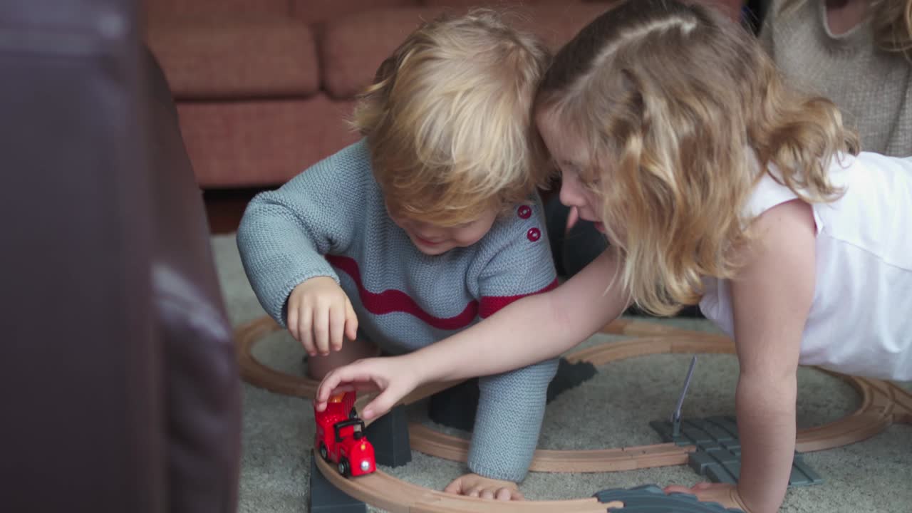 Mother with kids playing with toy roadway