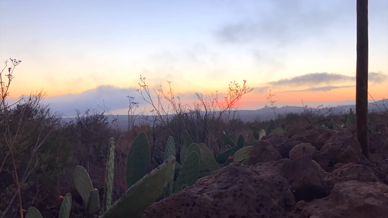 vívido atardecer cielo lapso de tiempo sobre árido desierto de cactus - tenerife, españa