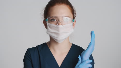 redheaded doctor in front of camera on gray background.