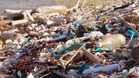 Nahaufnahme-Einer-Pfanne-Mit-Plastikmüll,-Die-Am-Felsigen-Strand-In-Der-Karibik-Verstreut-Ist