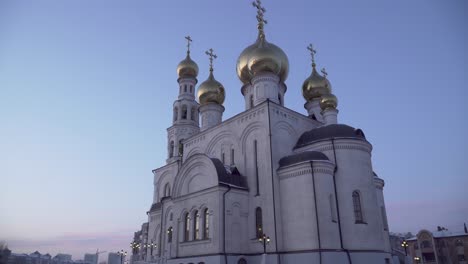 a white orthodox church with gold domes