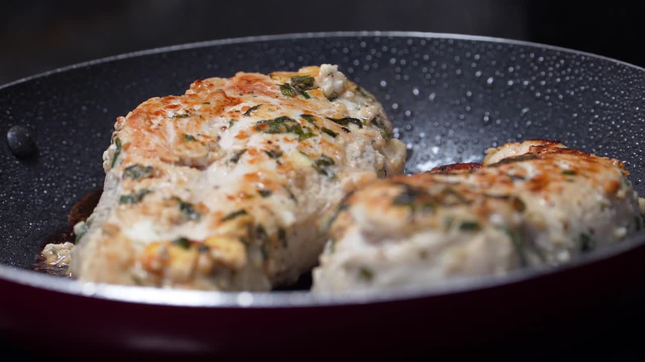 las pechugas de pollo se cocinan y se cocinan al vapor en una sartén cubriendo la deliciosa comida de la cena con una textura crujiente deliciosa y sazonada con tomillo, primer plano de la comida