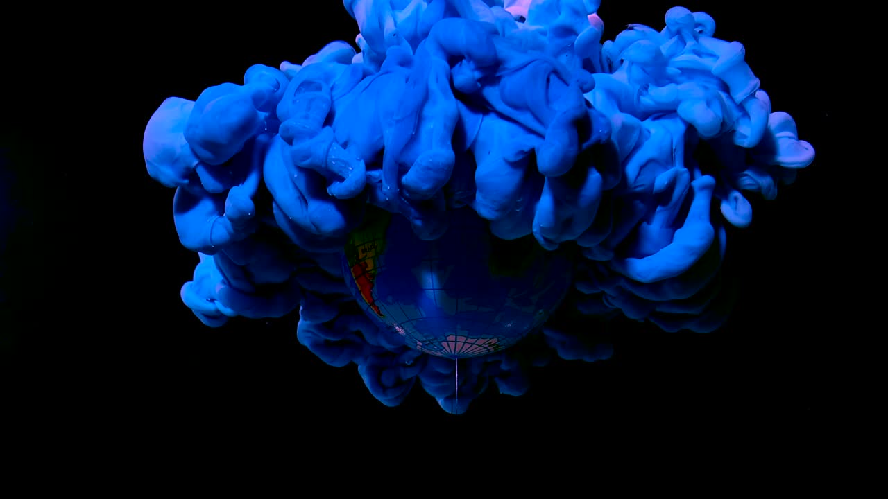 голубая планета земля из космоса. голубое и белое акварельное чернила в воде на черном фоне.