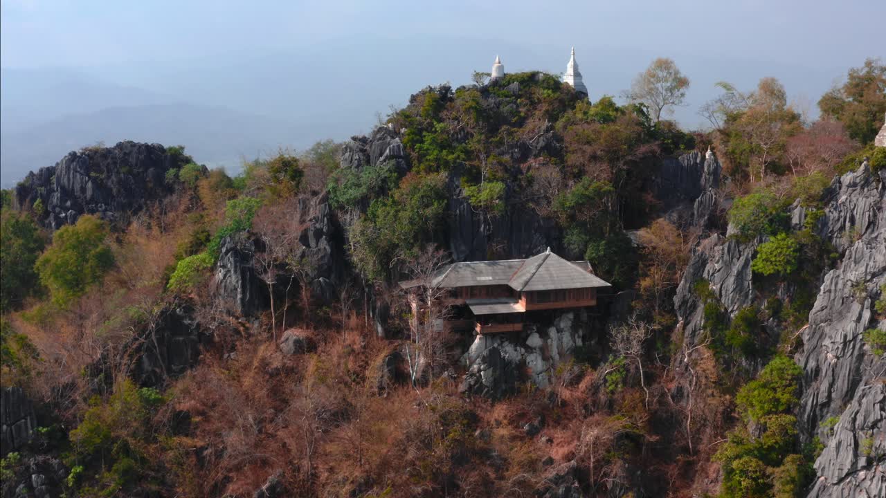 vista aérea de drones del templo budista tailandés en el cielo en la cima de las montañas rocosas