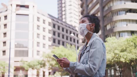 mujer de raza mixta con máscara médica de coronavirus en la calle