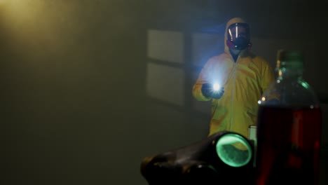 hazmat suit wearing man explores a dark room