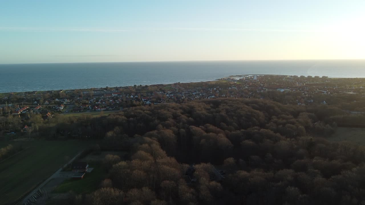 Taltioi Tanskan Saebyn ja upean Kattegatinmeren henkeäsalpaava kauneus tällä elokuvamaisella 4K-dronevideolla. Tämä korkealta kuvattu otos esittelee viehättävän kaupungin, joka sijaitsee rehevien metsien keskellä