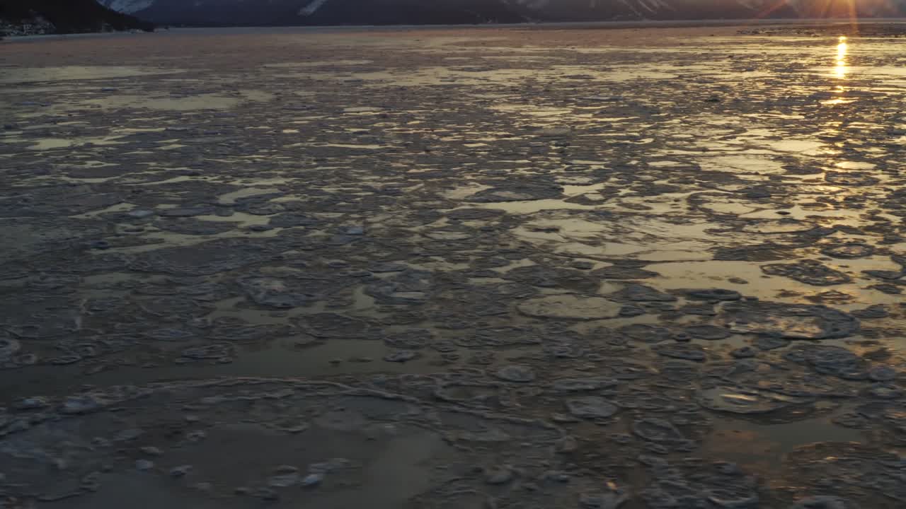 Best cinematic aerial footage of Cook Inlet during sunrise peaking over mountain