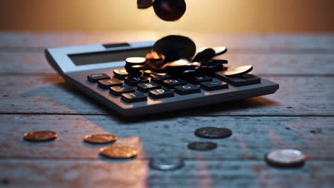 calculator and coins on wooden table