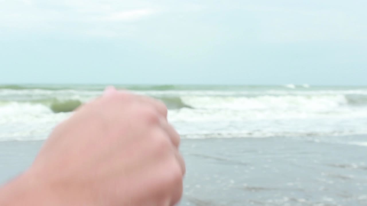 모래 해변 에 있는 병 에서 메시지 를 열고 있는 젊은 사람