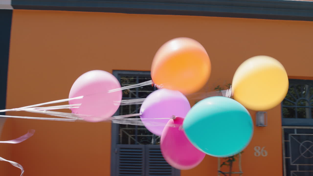 chica con globos coloridos corriendo en la calle de la ciudad fiesta de cumpleaños celebrando el verano divertido 4k